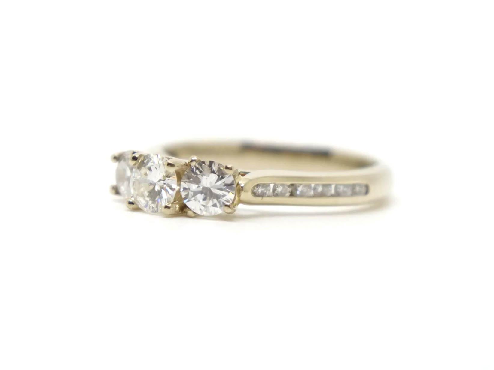 Very pretty 18ct gold diamond three stone ring, set with three brilliant cut diamonds, with further diamonds set into each shoulder. Total diamond weight approximately 1ct.