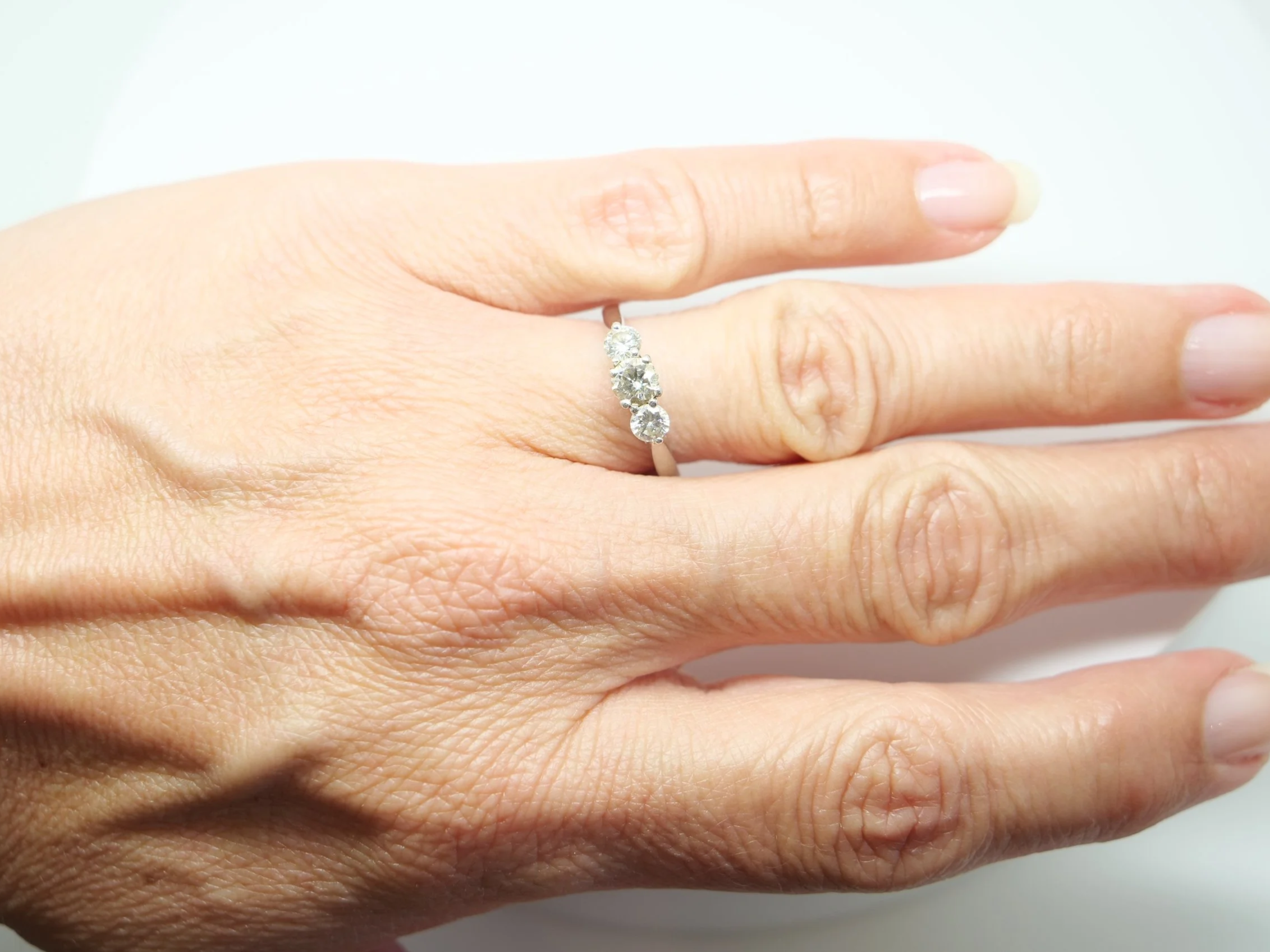 Platinum three stone diamond ring, three round brilliant cut diamonds in claw settings, hallmarked 2010, UK size L