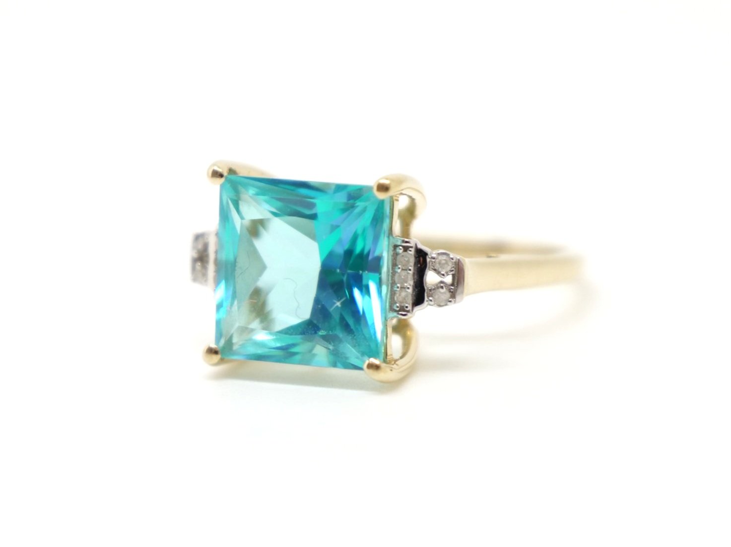Large 9ct gold bright blue topaz and diamond coktail ring, set with a square cut blue topaz of approximately 5.8cts, with diamonds set to each shoulder.