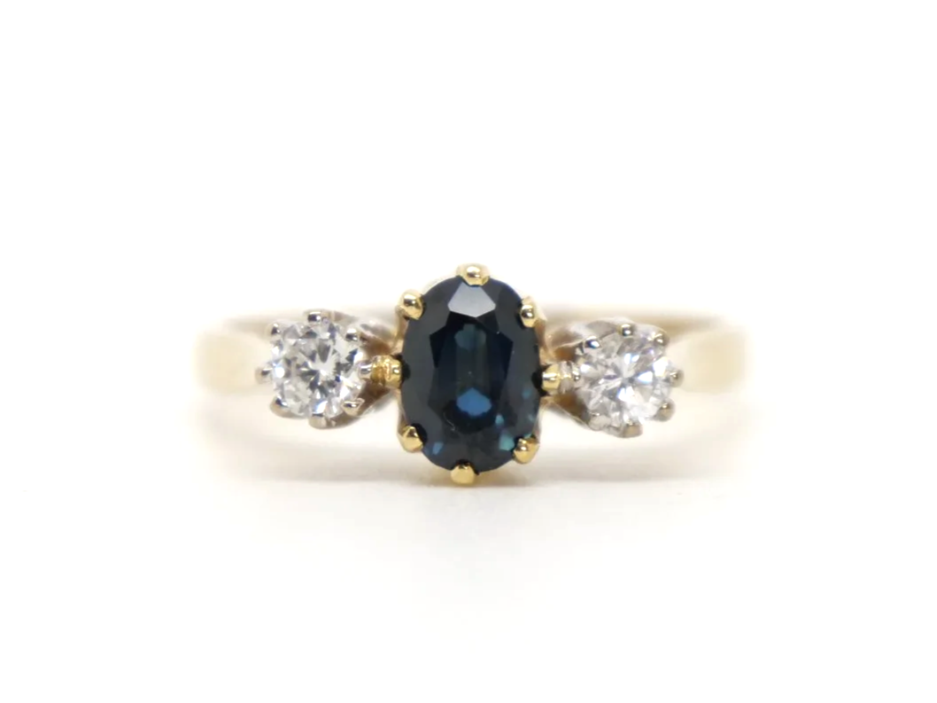 Classic 18ct gold vintage sapphire and diamond trilogy ring, set with an oval cut sapphire with a brilliant cut diamond to each shoulder.