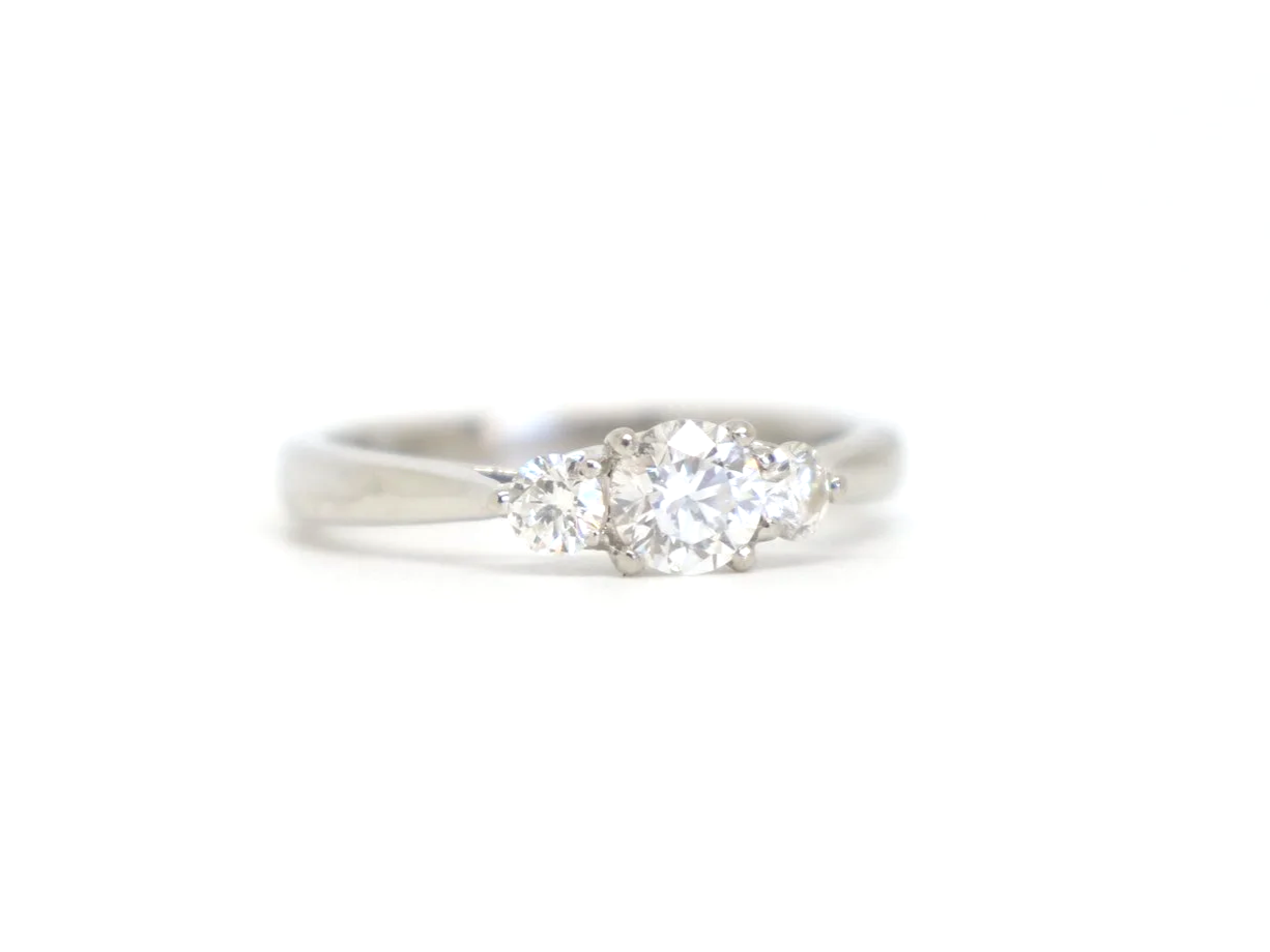 Platinum three stone diamond ring, central diamond flanked by two round diamonds