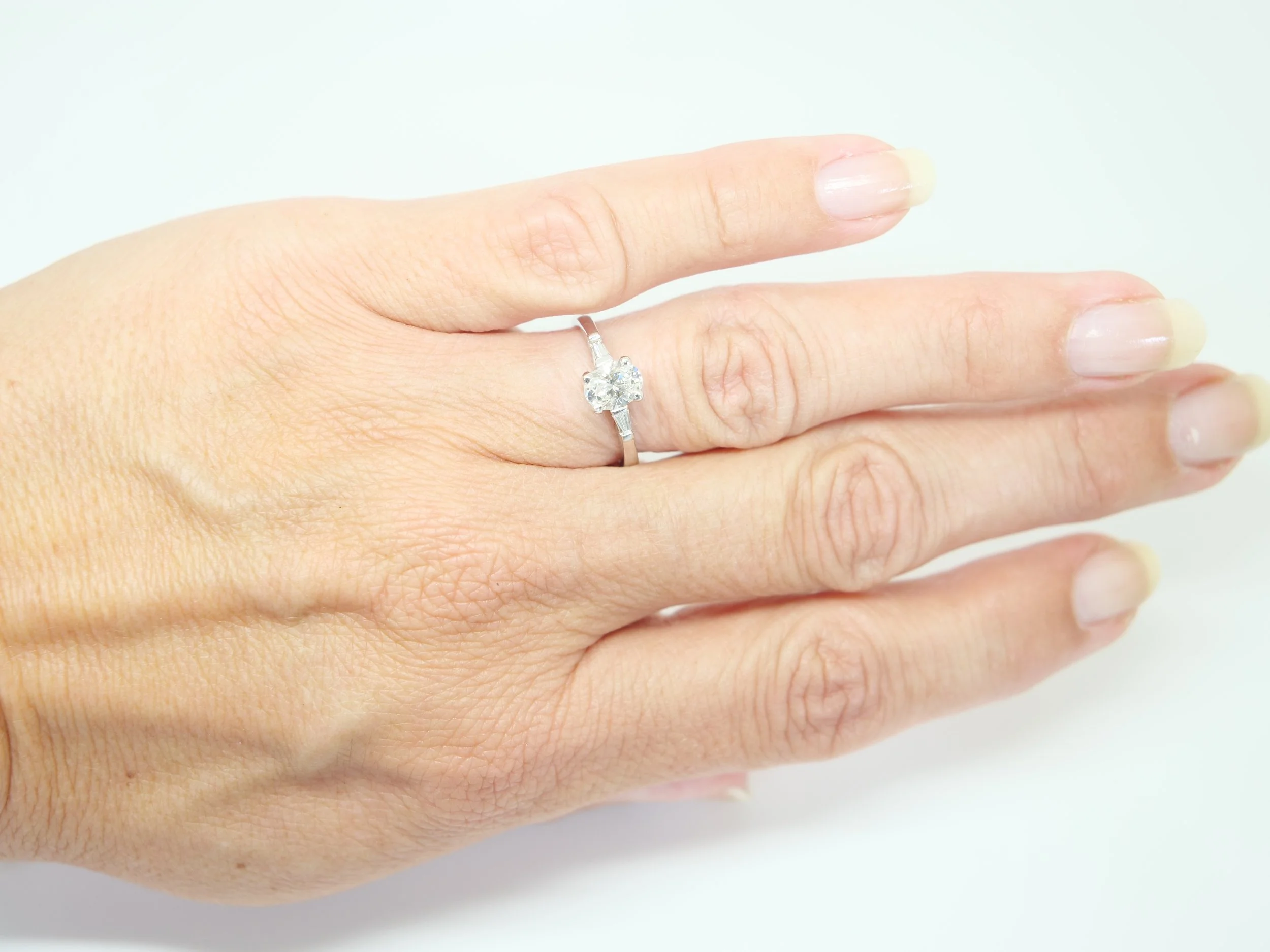 18ct white gold oval diamond solitaire ring with tapered baguette shoulders