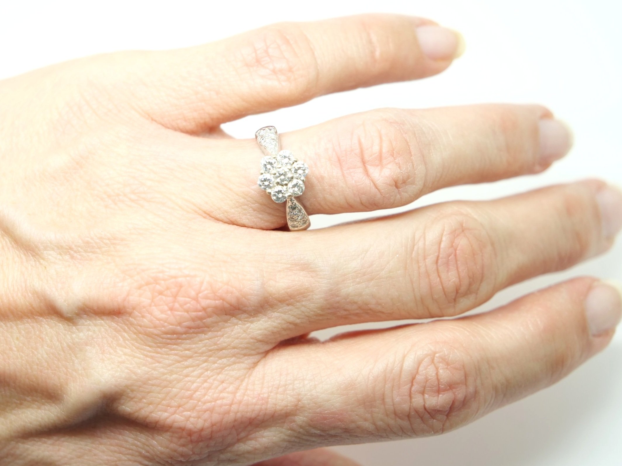 Very pretty 18ct gold diamond daisy ring, set with a central diamond flower cluster, with diamonds set into each shoulder.