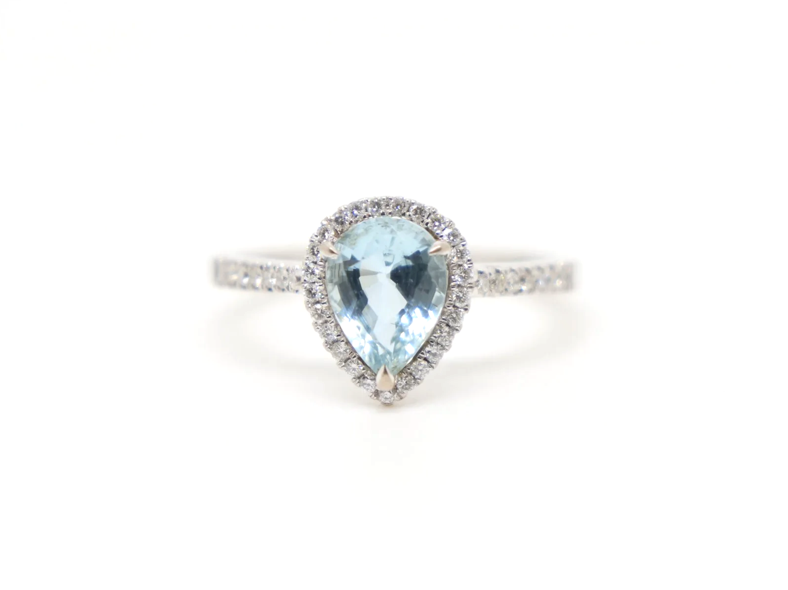 18ct white gold aquamarine and diamond halo ring, set with a pear cut aquamarine at the centre