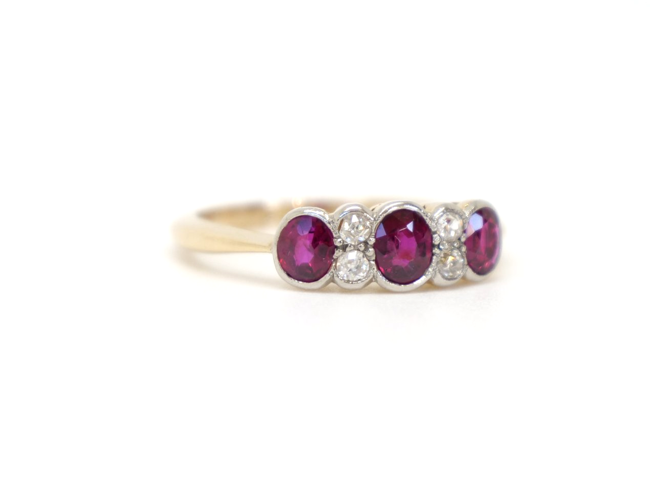 Vintage 18ct gold ruby and diamond ring, set with three oval cut rubies and inset with old cut diamonds.