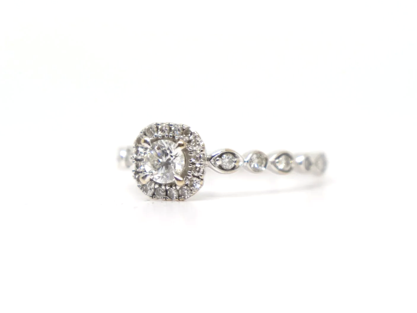 A platinum diamond halo ring by Emmy London, set with a round brilliant cut diamond at the centre surrounded by a cushion-shaped halo of smaller diamonds