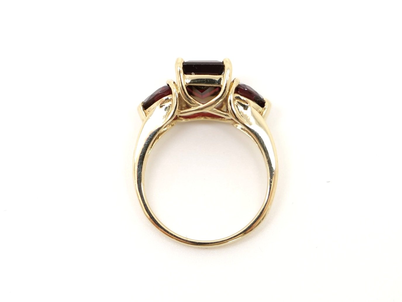 Super 9ct gold garnet cocktail ring, set with a central emerald cut garnet, with a trilliant garnet to each side.