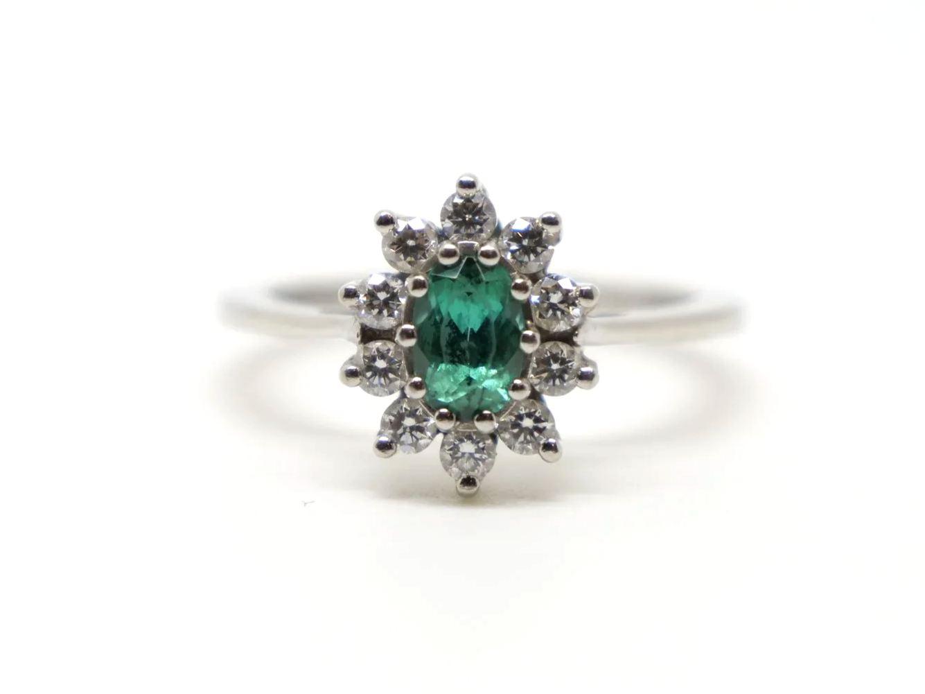 Unusual platinum green tourmaline and diamond cluster ring, set with an oval cut green tourmaline and surrounded by lovely sparkly diamonds.