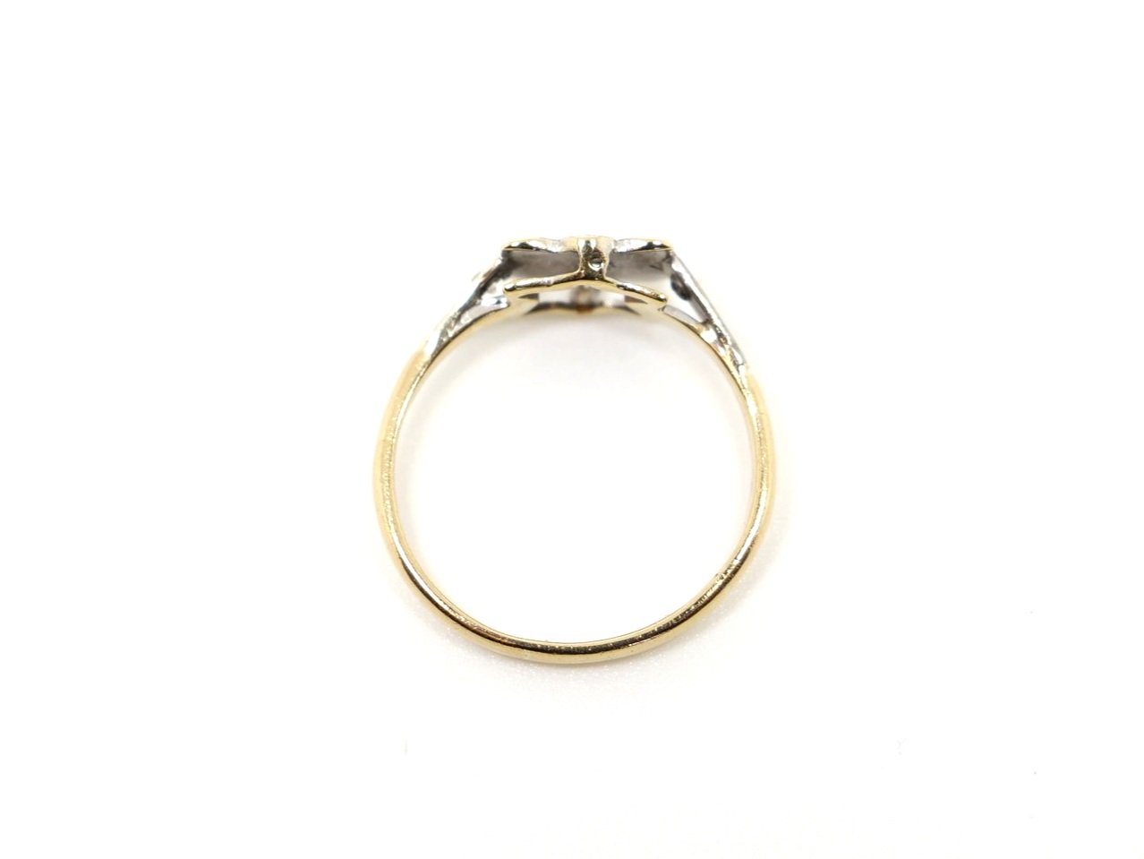 Very pretty 18ct gold Art deco diamond ring, in an unusual floral bow design and set with three small central diamonds. A further diamond set to each shoulder.