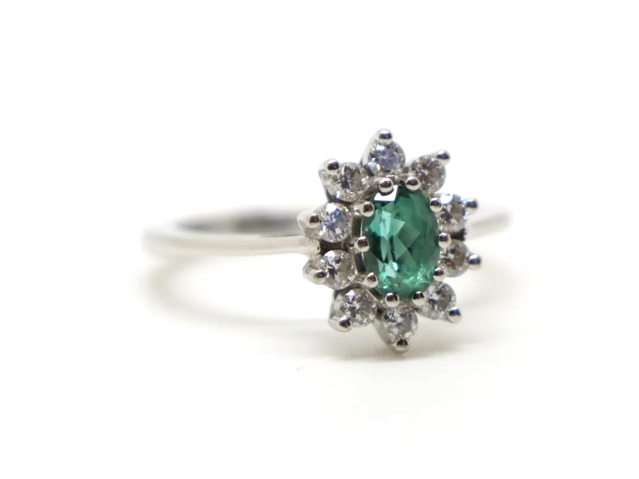 Unusual platinum green tourmaline and diamond cluster ring, set with an oval cut green tourmaline and surrounded by lovely sparkly diamonds.