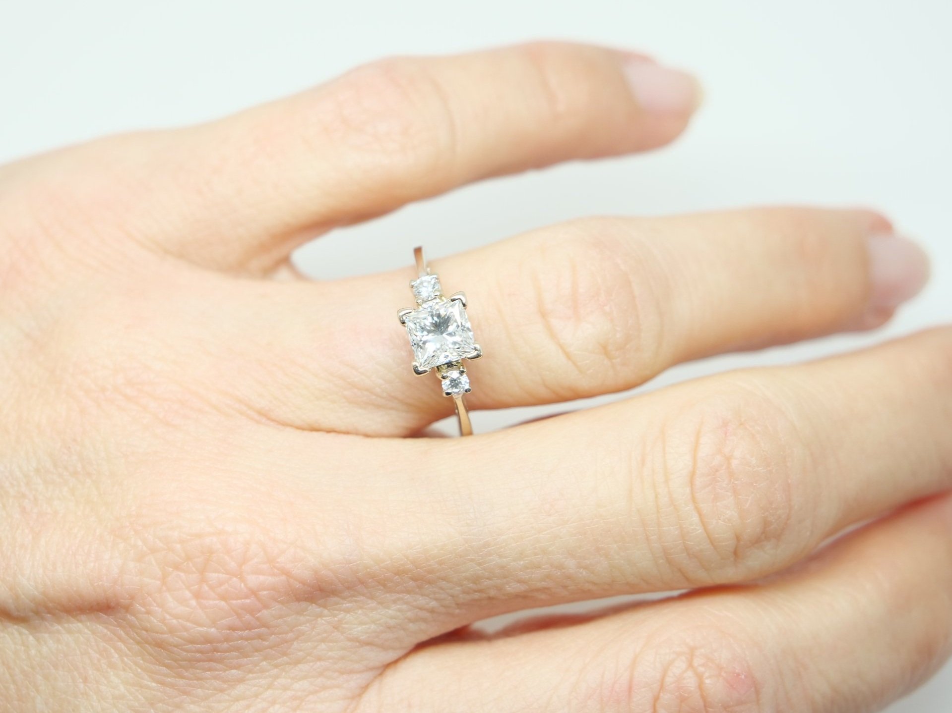 Superb diamond engagement ring, set with a GIA certified 1ct G colour and VS1 clarity modified square cut diamond. With a brilliant cut diamond to each shoulder.