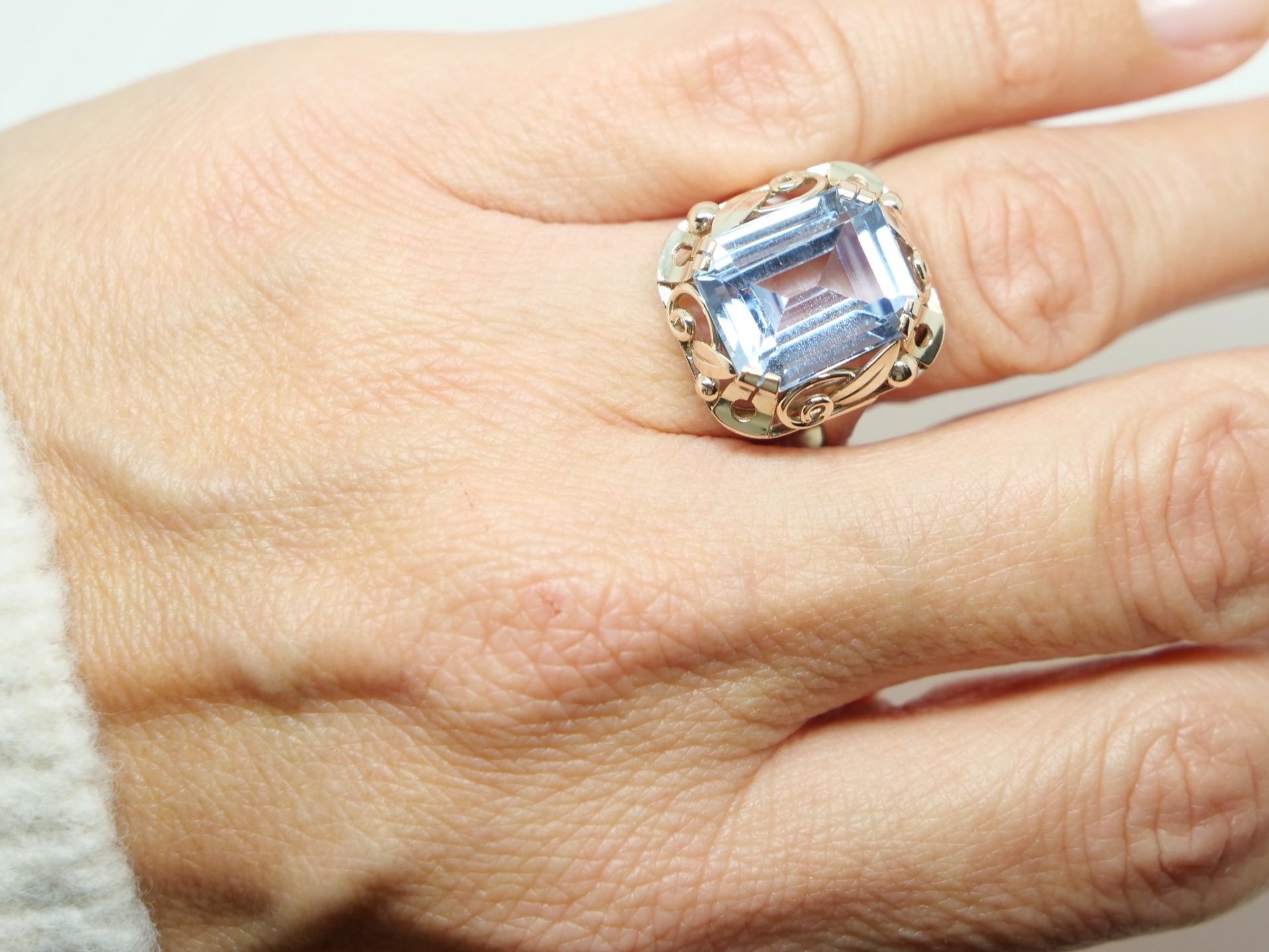 Beautiful vintage cocktail ring in 8ct gold, set with a large emerald cut blue spinel. Pretty gold scroll design all around the setting.