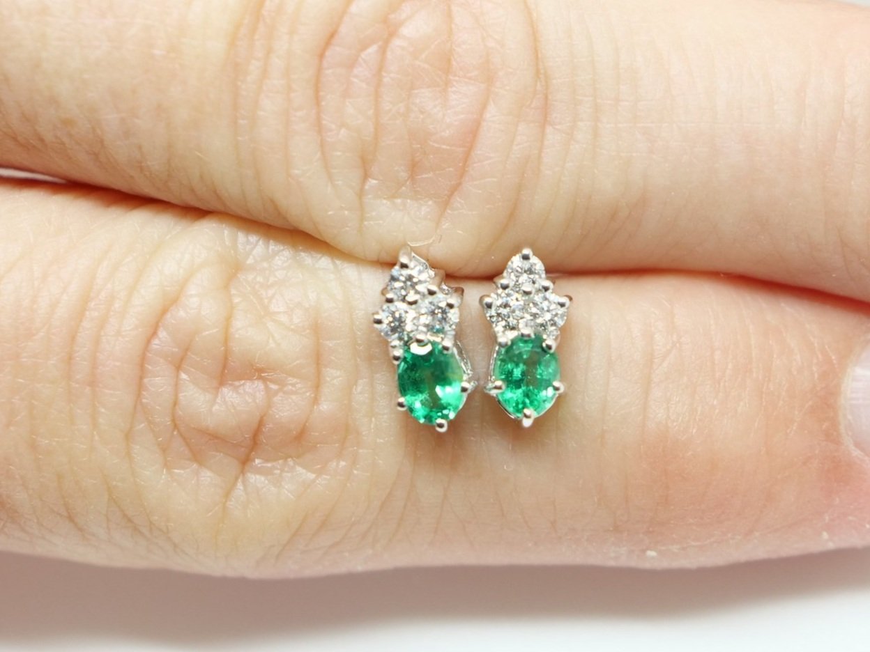 Lovely quality 18ct gold emerald and diamond earrings, each set with an oval cut emerald, with three small diamonds above. With 18ct butterflies.