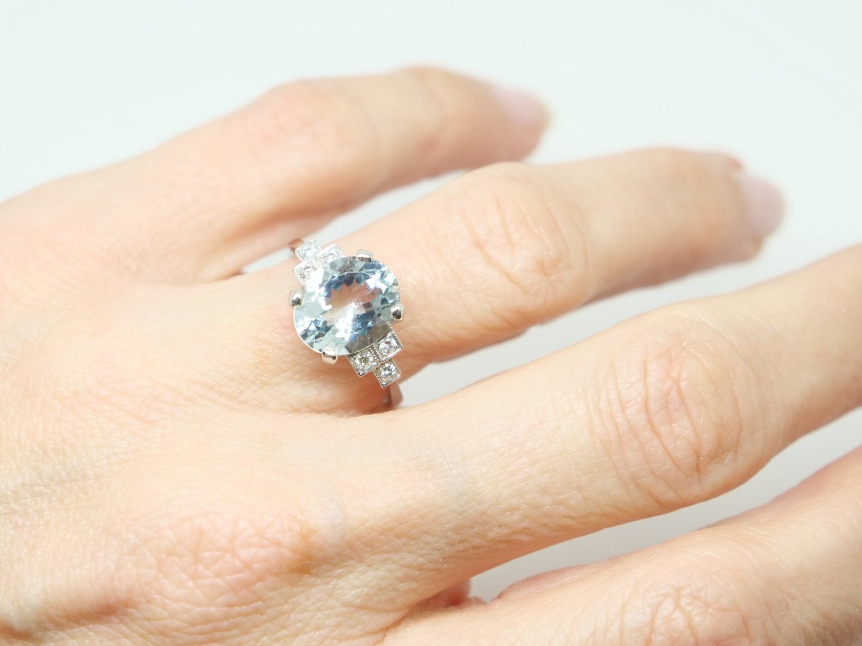Super platinum Art Deco style aquamarine and diamond ring, set with a central oval cut aquamarine of approximately 3cts, with diamonds set in a step design into each shoulder.