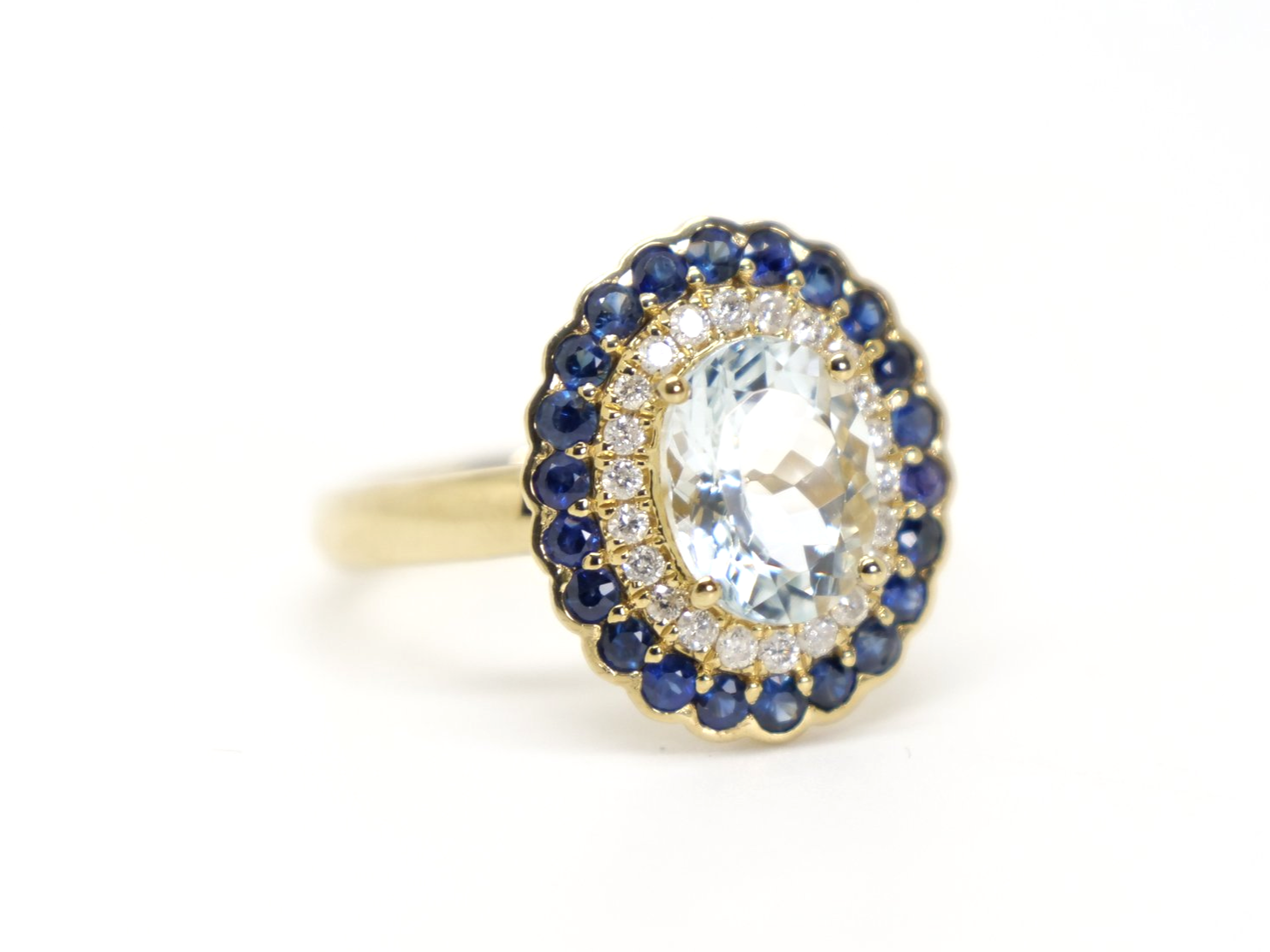 Very unusual 18ct gold aquamarine, diamond and sapphire cluster ring, set with a large central aquamarine and surrounded by diamonds and then sapphires.