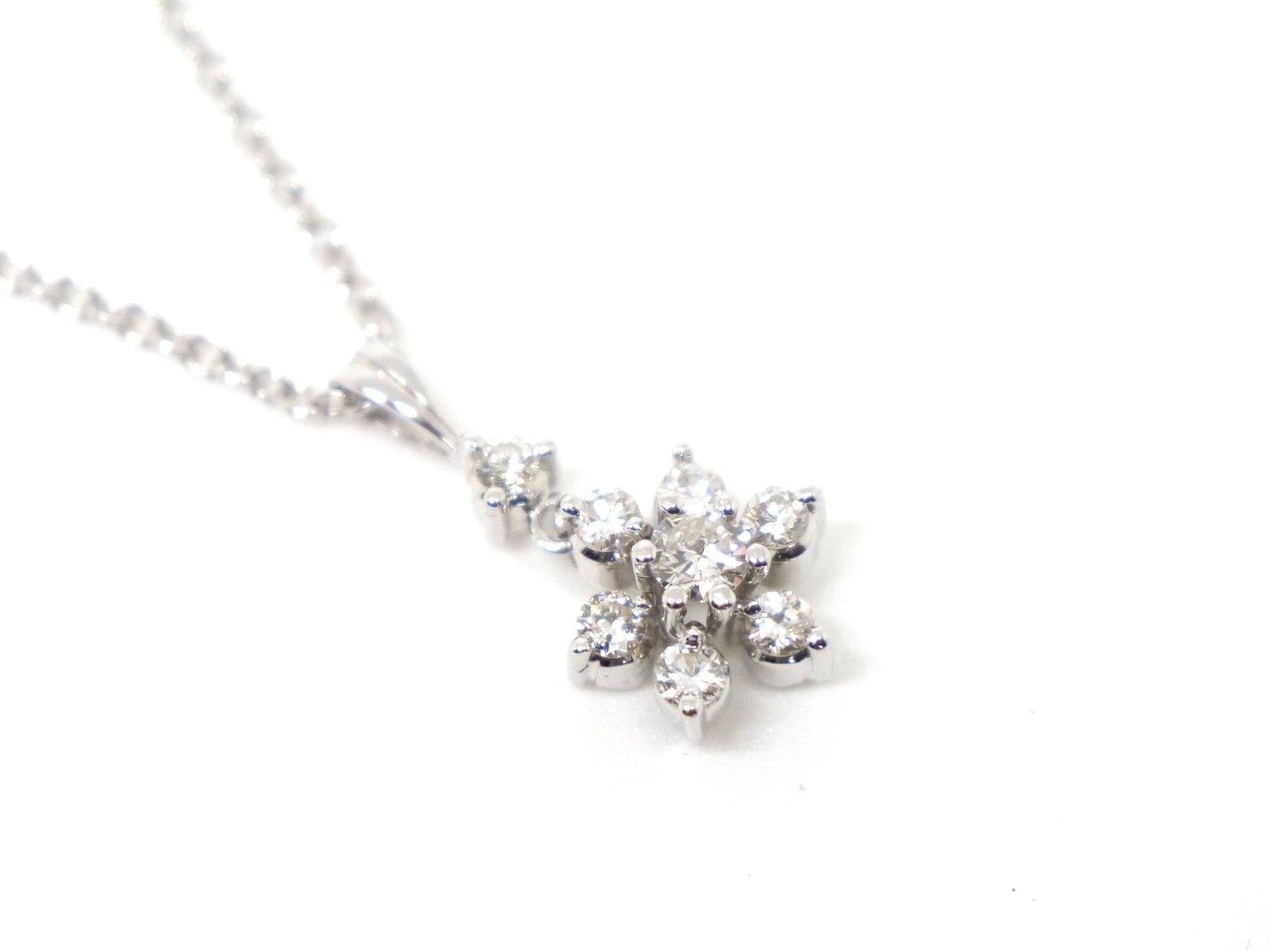 Very elegant 9ct gold diamond flower pendant and chain, set with a small drop diamond and then a lovely diamond flower. Approximately 0.5ct diamonds total.