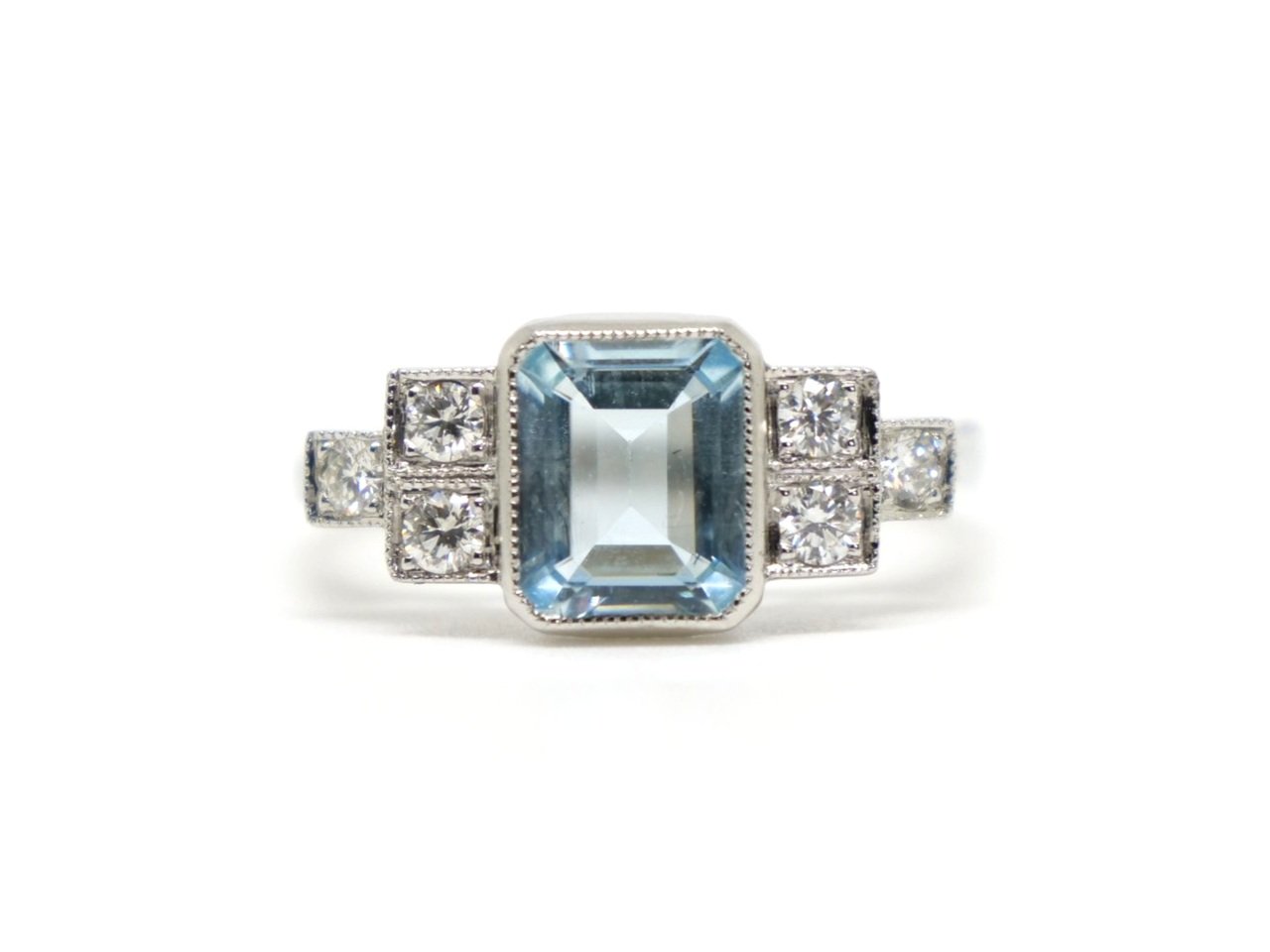 Beautiful Art Deco style platinum aquamarine and diamond ring, set with a central emerald cut aquamarine, with three diamonds set in a step design to each shoulder.