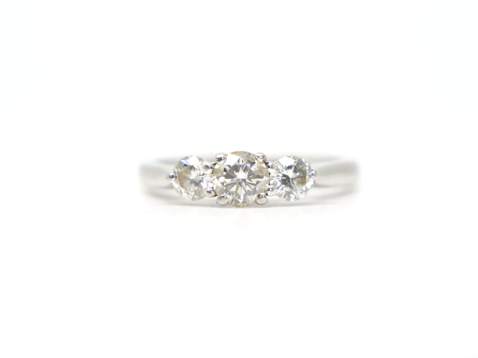 Platinum three stone diamond ring, three round brilliant cut diamonds in claw settings, hallmarked 2010, UK size L