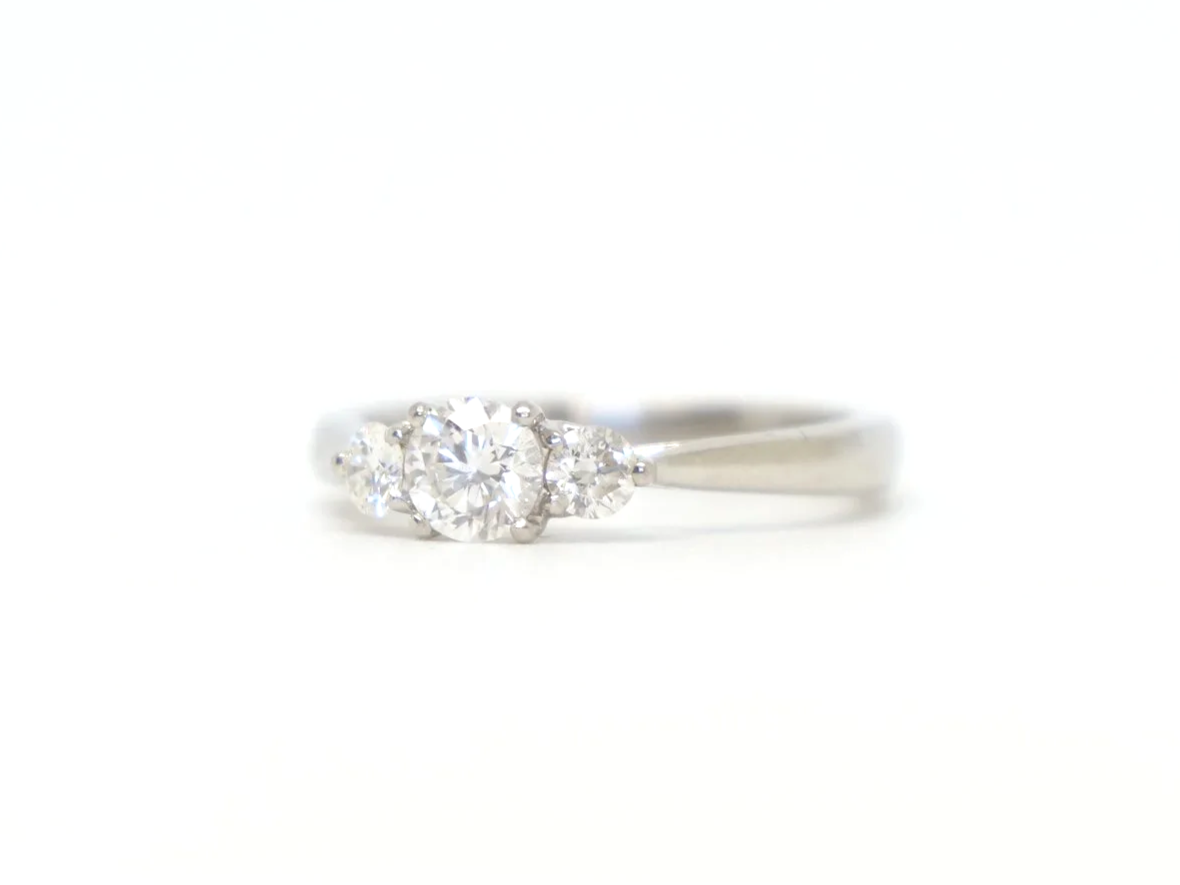 Platinum three stone diamond ring, central diamond flanked by two round diamonds