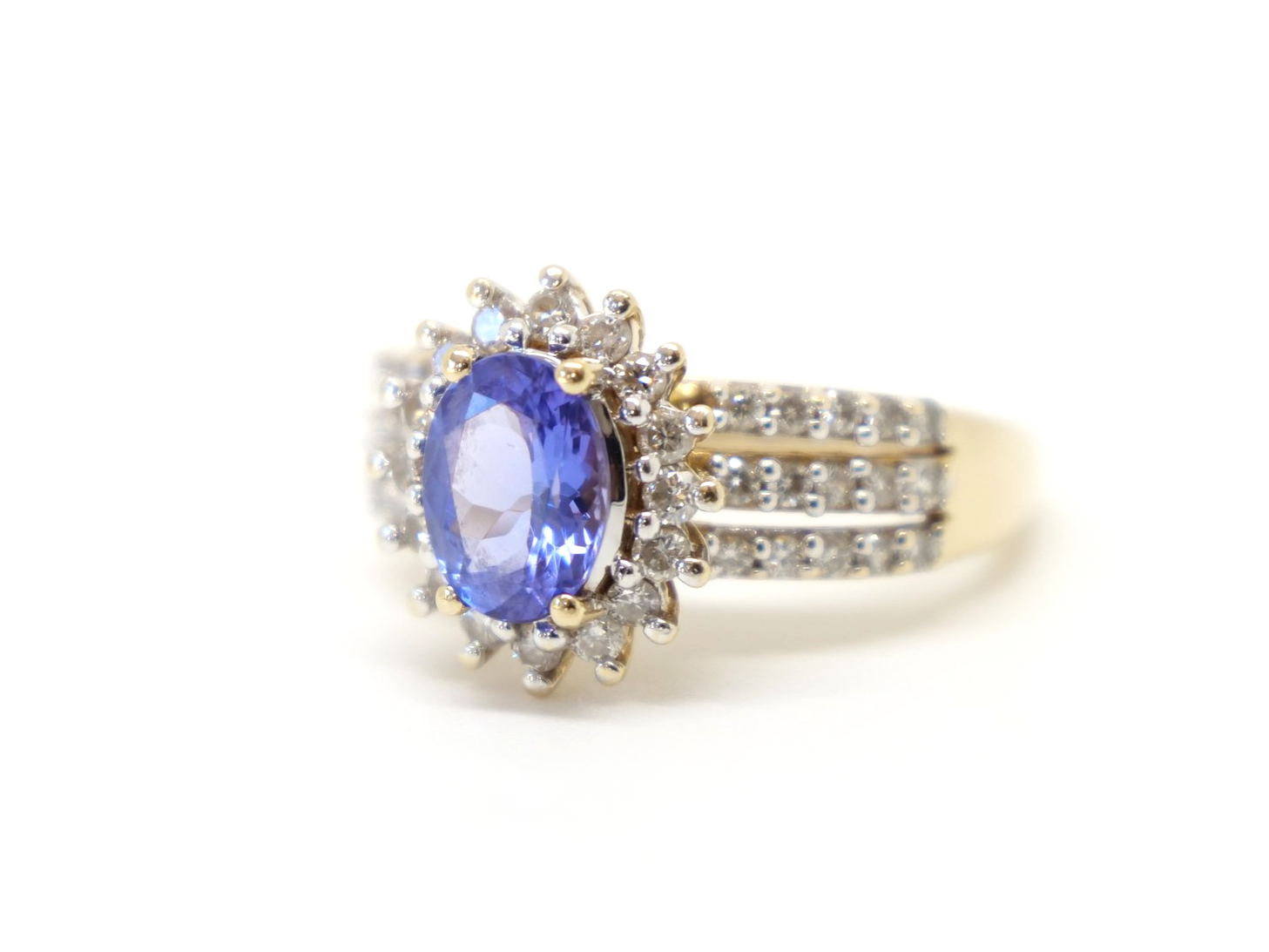 Statement 14ct gold tanzanite and diamond cocktail ring, set with an oval cut tanzanite and surrounded by diamonds. Further diamonds in three rows down each shoulder.