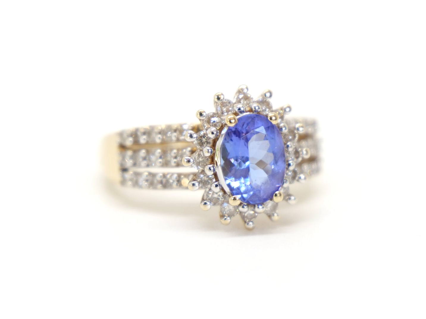 Statement 14ct gold tanzanite and diamond cocktail ring, set with an oval cut tanzanite and surrounded by diamonds. Further diamonds in three rows down each shoulder.