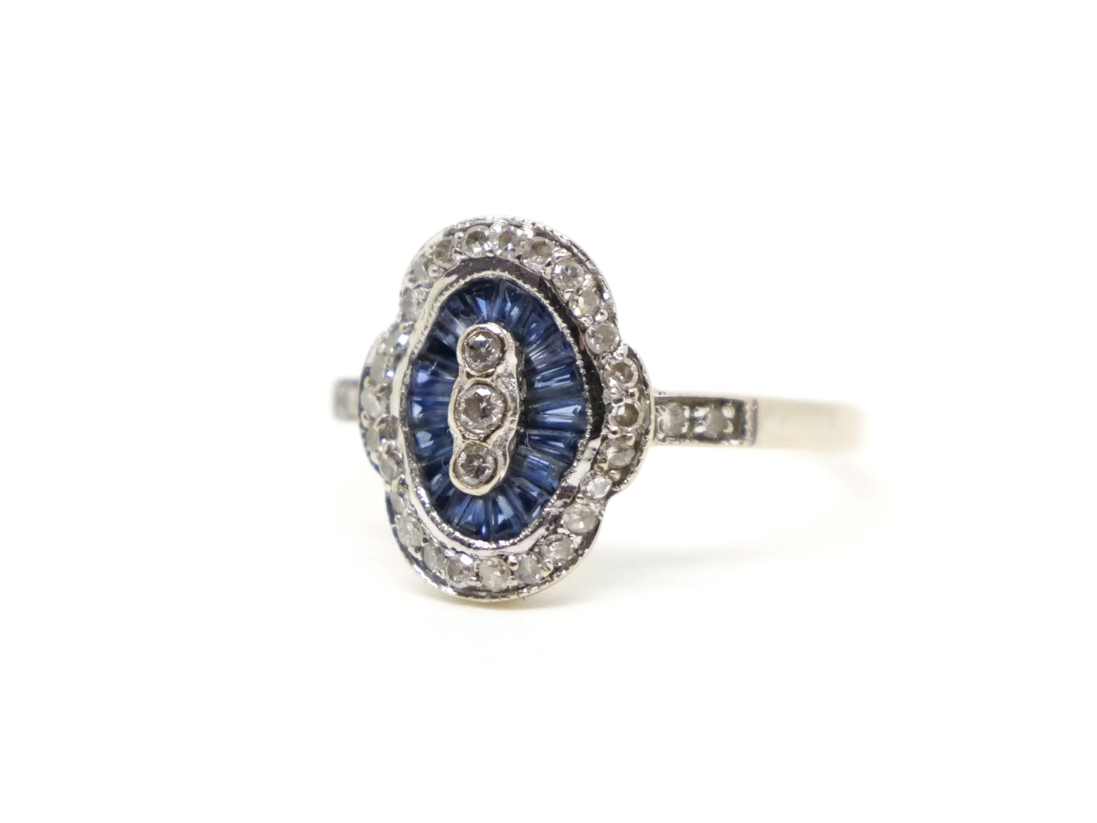 Unusual 18ct gold sapphire and diamond ring in this lovely Art Deco design. Set with calibre cut sapphires and small diamonds.
