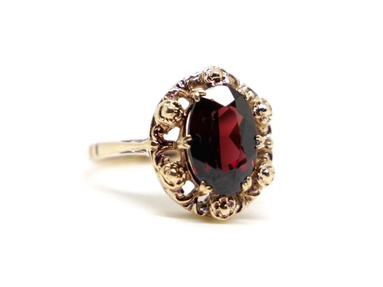 Lovely vintage 9ct gold cocktail ring, set with an oval cut garnet. Pretty gold fretwork around the whole of the ring.