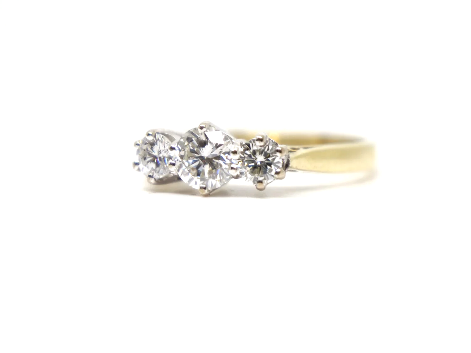 A classic 18ct gold diamond three stone ring from 1997, set with three round brilliant cut diamonds of approximately 1 carat in total.