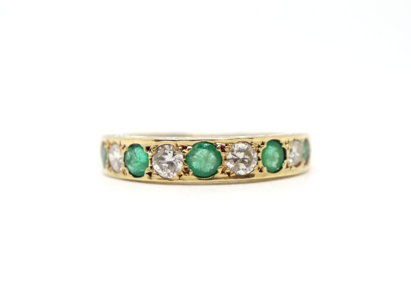 Lovely vintage 18ct gold emerald and diamond half eternity ring, set with four brilliant cut diamonds and five emeralds. Scroll detail to top and bottom.