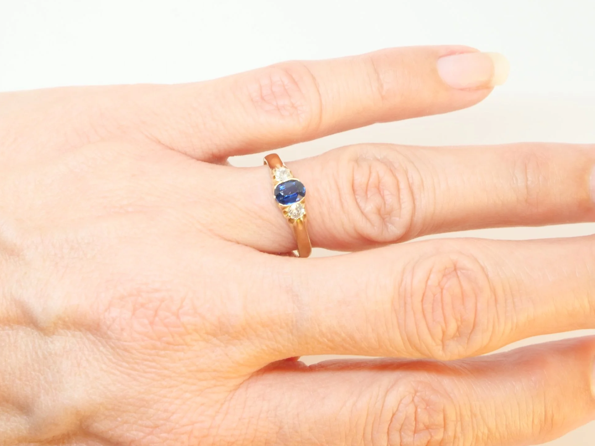 Vintage 18ct gold sapphire and diamond trilogy ring, set with a lovely blue sapphire with an old cut diamond to each side.