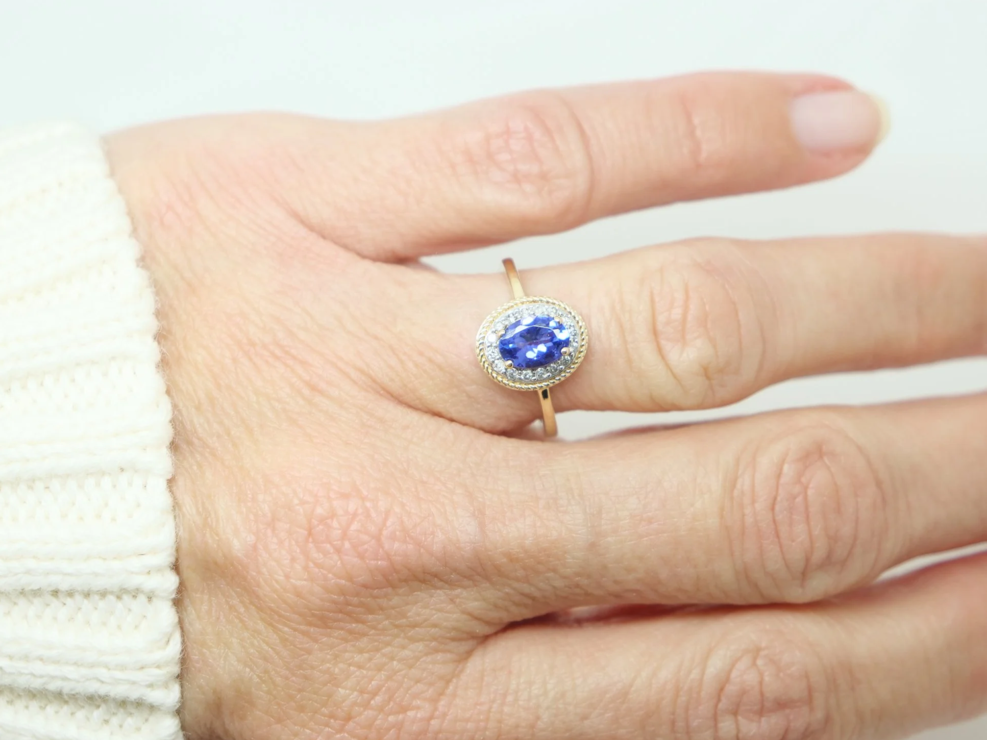 Very pretty oval design 9ct gold tanzanite and diamond ring, set with a vibrant purple tanzanite and surrounded by small diamonds.