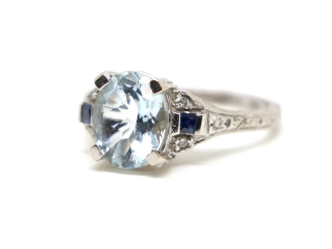 Gorgeous aquamarine, sapphire and diamond ring, set with an oval cut aquamarine with a step cut sapphire to each side. Diamonds set to each shoulder.