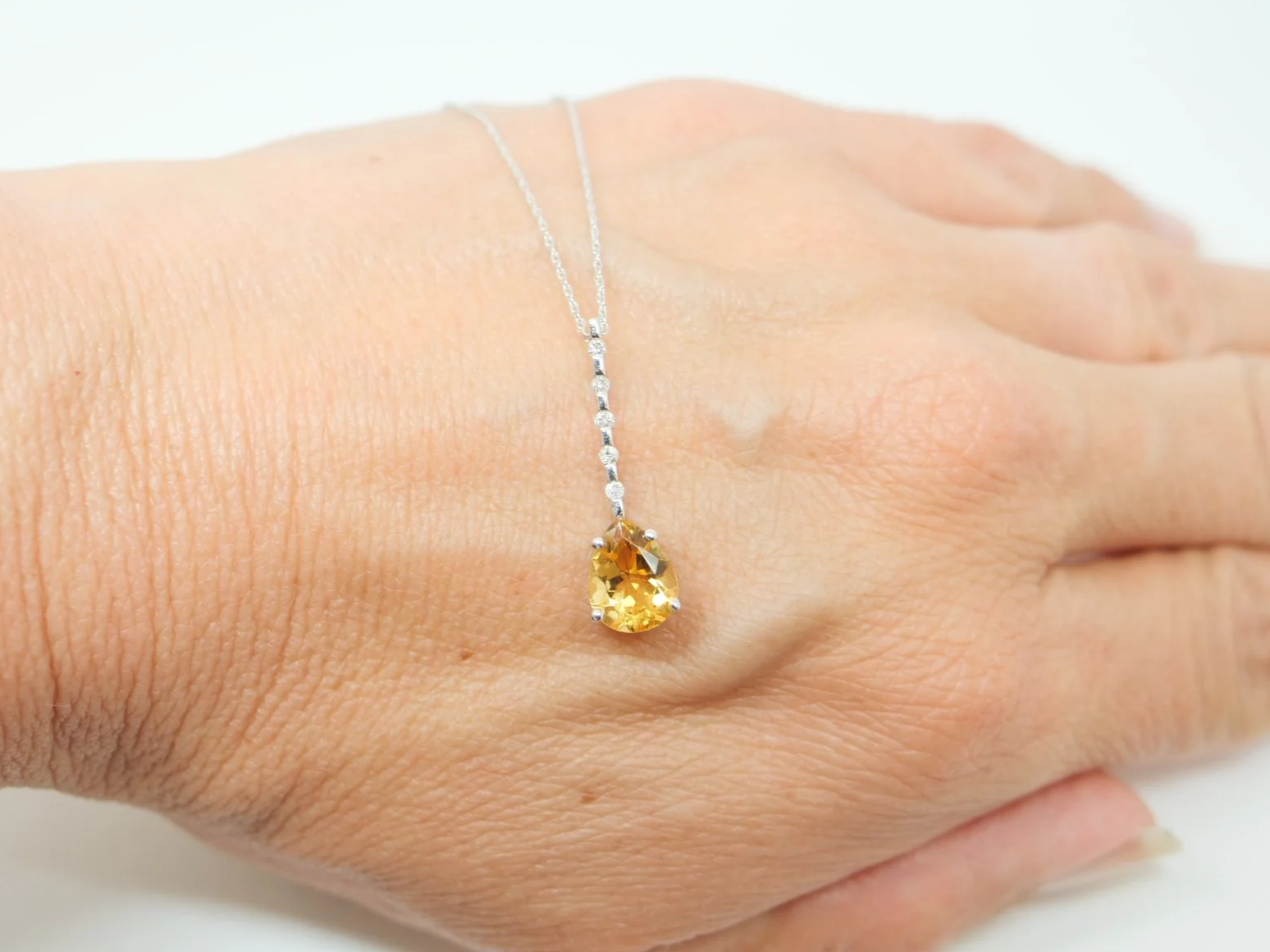 A 9ct white gold citrine and diamond pendant
