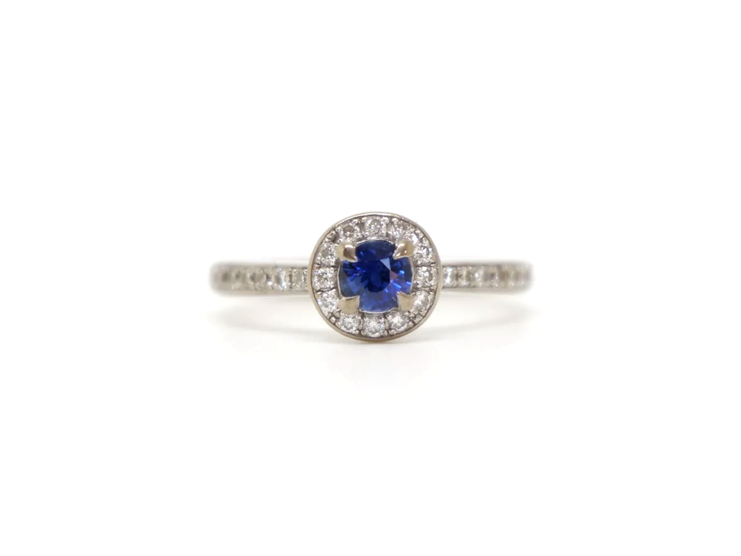 Lovely sapphire and diamond halo ring in 18ct white gold, set with a round-cut blue sapphire of approximately 0.35ct, and encircled by a halo of brilliant-cut diamonds