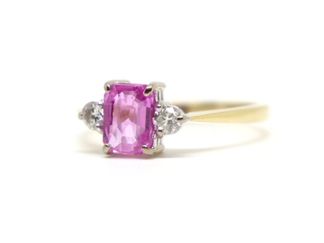 Very pretty 18ct gold pink sapphire and diamond trilogy ring, set with a central emerald cut pink sapphire of approximately 1.1cts, with a diamond to each side.