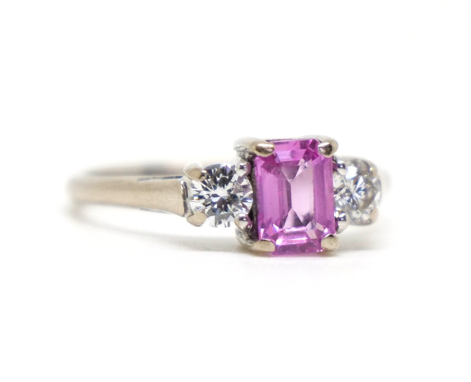 Very pretty 18ct gold classic pink sapphire and diamond trilogy ring, set with a 0.75ct emerald cut pink sapphire with a brilliant cut diamond to each side.