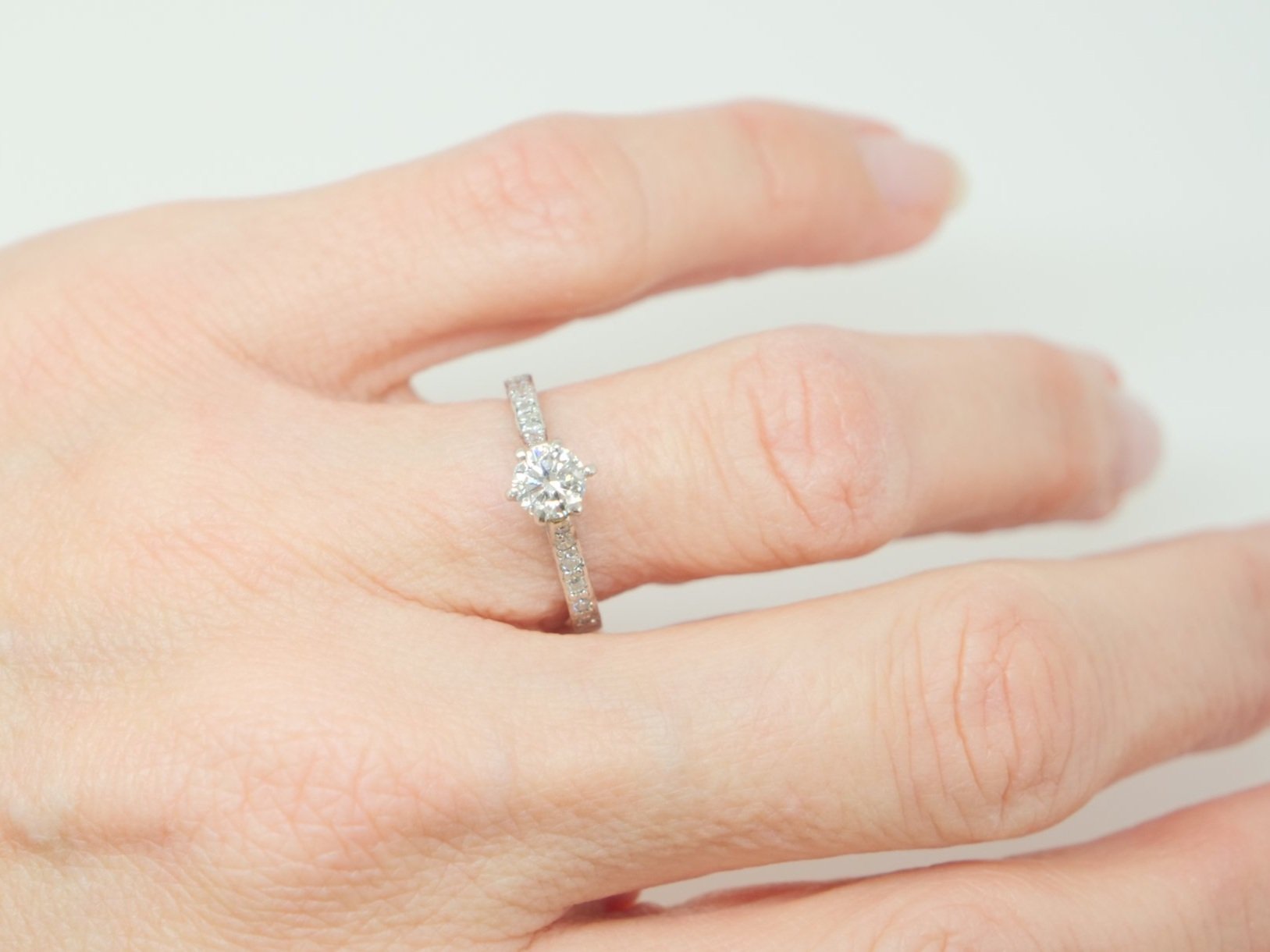 Super platinum gold diamond solitaire ring, set with a central brilliant cut diamond of approximately 0.55cts, with further brilliant cut diamonds set into each shoulder.