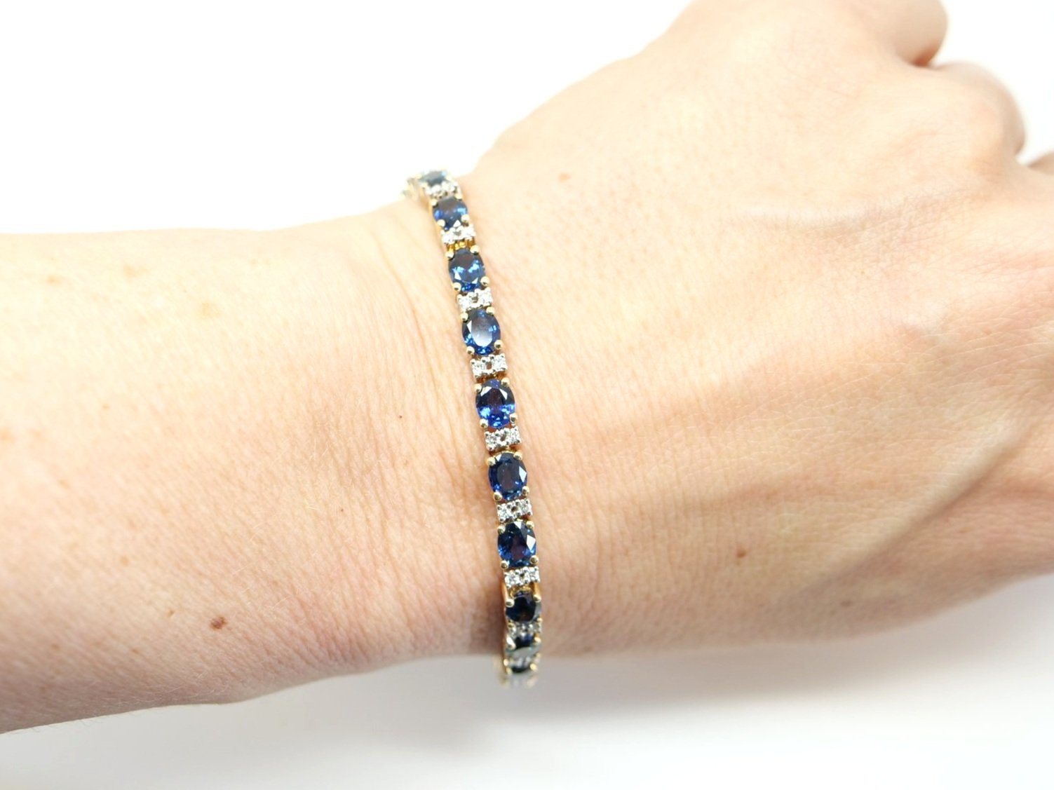 Super 14ct gold sapphire and diamond bracelet, set with lively oval cut blue sapphires interset with small diamonds. Clip over safety catch to keep secure.