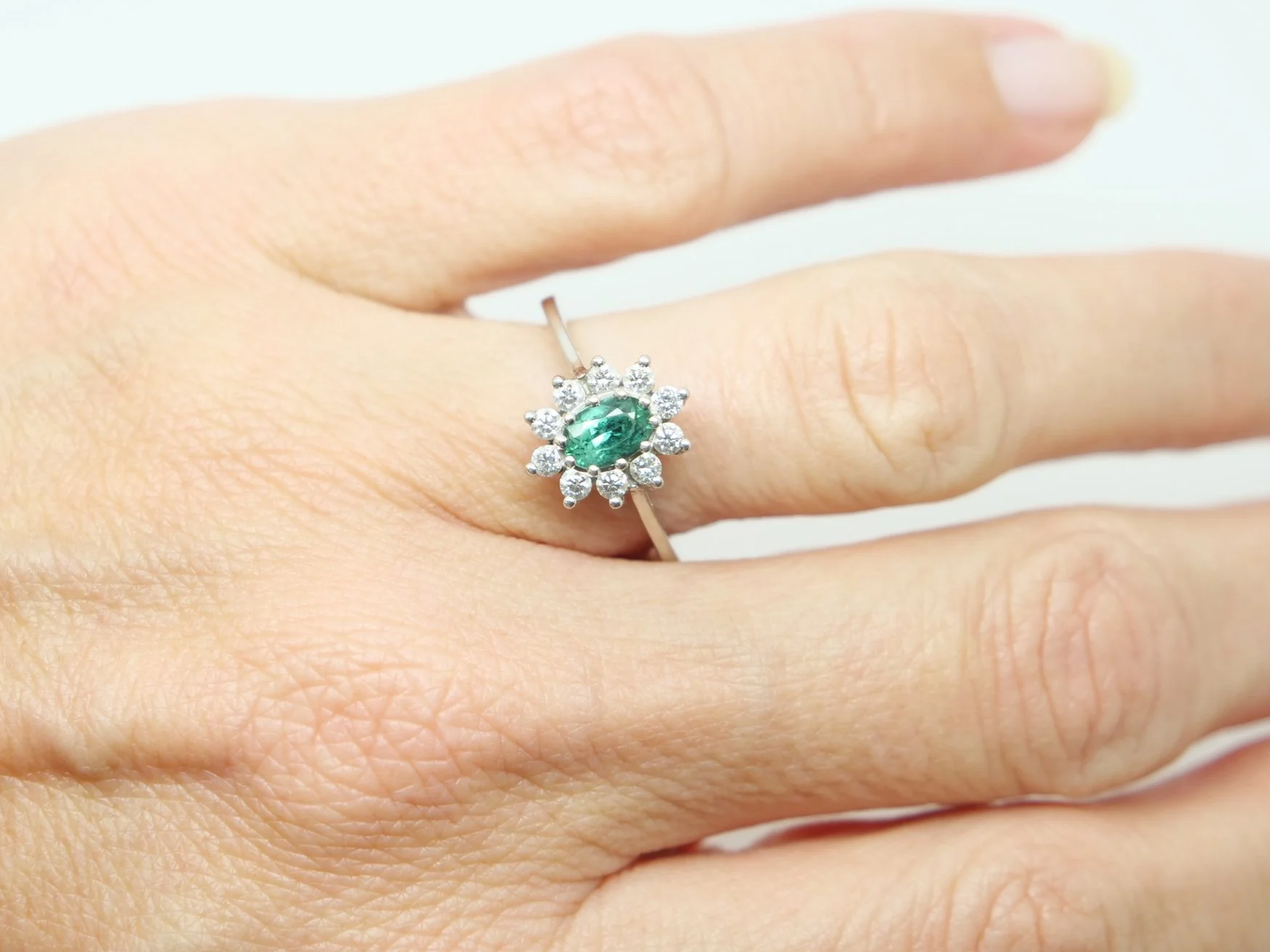 Unusual platinum green tourmaline and diamond cluster ring, set with an oval cut green tourmaline and surrounded by lovely sparkly diamonds.