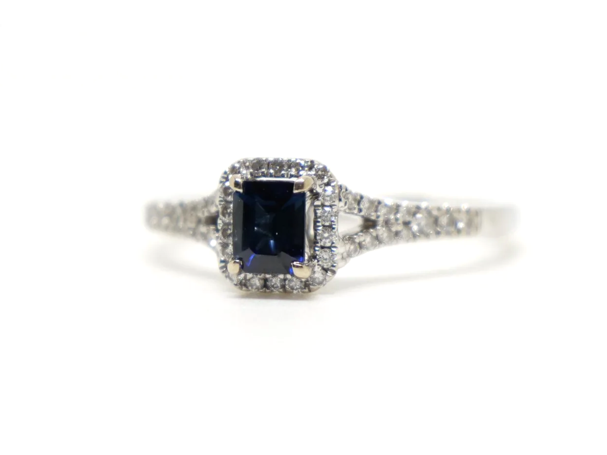 Very pretty contemporary 18ct gold sapphire and diamond ring, set with an emerald cut sapphire with diamond halo.