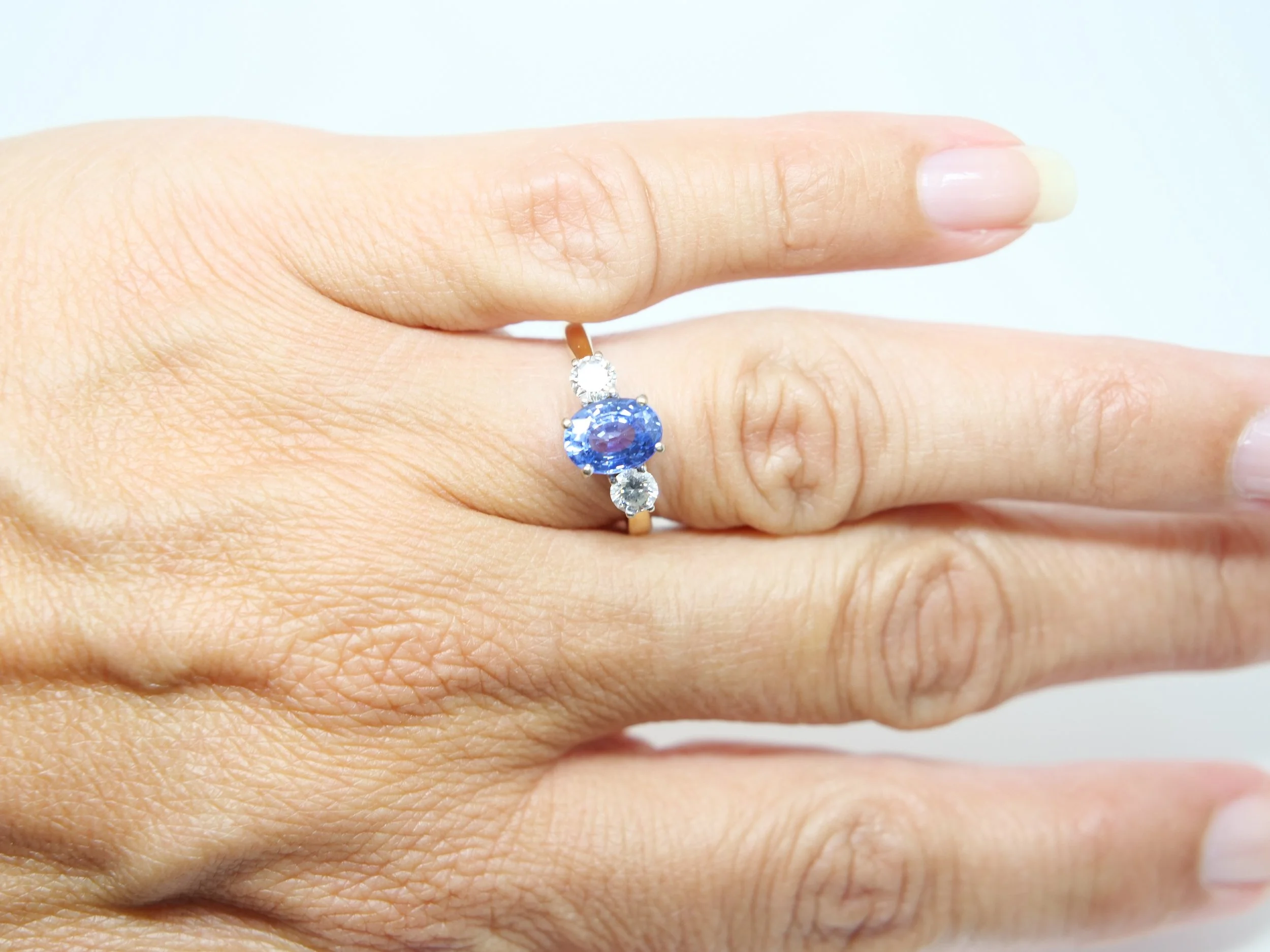 Superb 18ct gold oval cut Ceylon sapphire and diamond trilogy ring, set with a 1.55ct oval cut Ceylon sapphire with a brilliant cut diamond to each side (0.4ct diamonds).