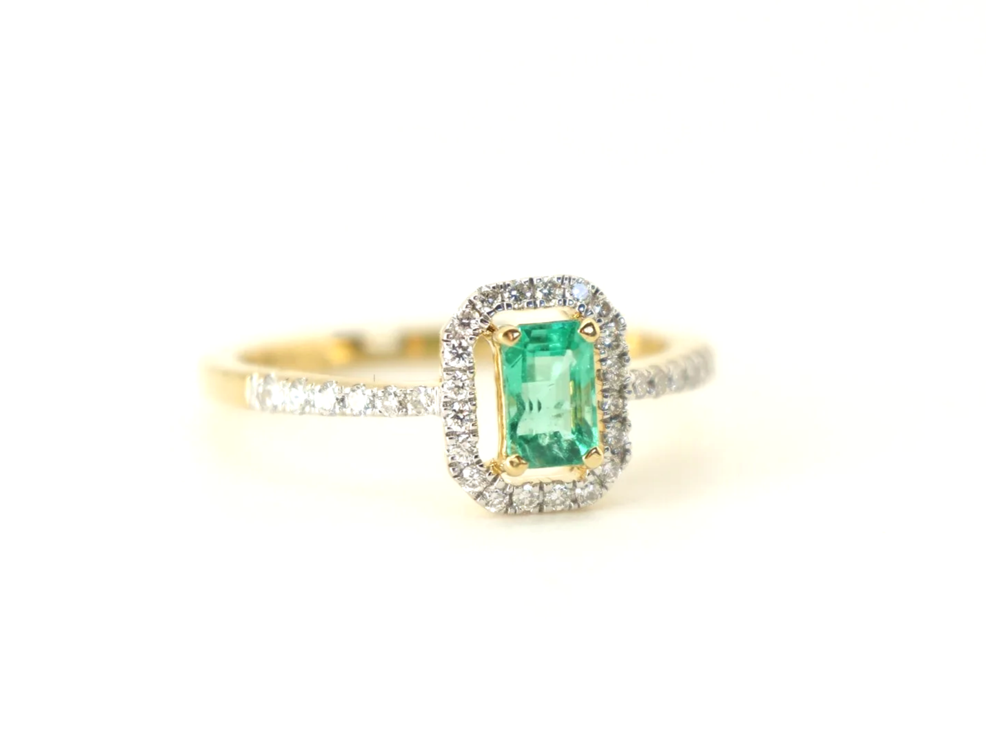 18ct gold emerald and diamond halo ring, emerald cut centre stone