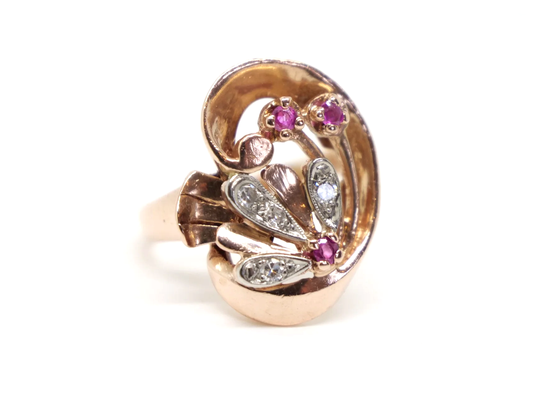 Very unusual 14ct rose gold Art Deco ring, in a large swirl style design. Each of the flower elements of the ring are set with round cut rubies, with diamonds set into each petal.