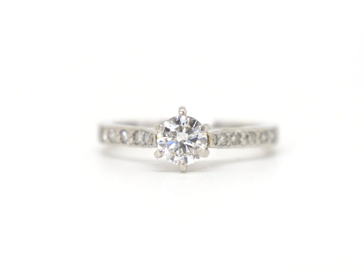 Super platinum gold diamond solitaire ring, set with a central brilliant cut diamond of approximately 0.55cts, with further brilliant cut diamonds set into each shoulder.