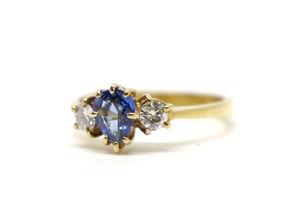 Beautiful vintage 18ct gold sapphire and diamond three stone ring, set with a pear cut sapphire and with a brilliant cut diamond to each side.