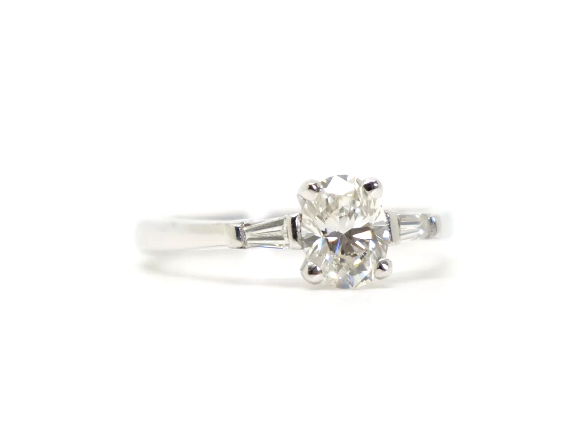 Gorgeous 18ct gold oval cut diamond solitaire ring, with an approximately 0.65ct oval cut diamond and with a tapered baguette to each shoulder.