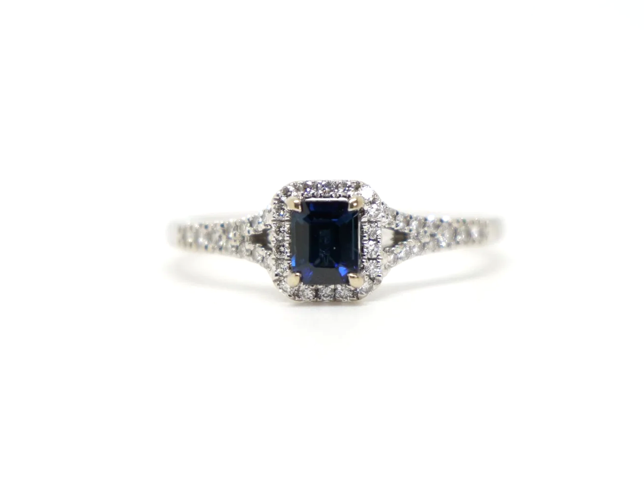 Very pretty contemporary 18ct gold sapphire and diamond ring, set with an emerald cut sapphire with diamond halo.