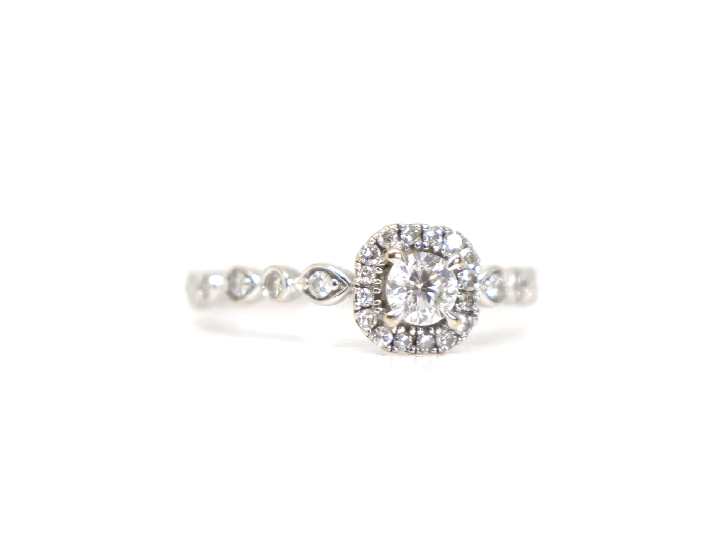 A platinum diamond halo ring by Emmy London, set with a round brilliant cut diamond at the centre surrounded by a cushion-shaped halo of smaller diamonds