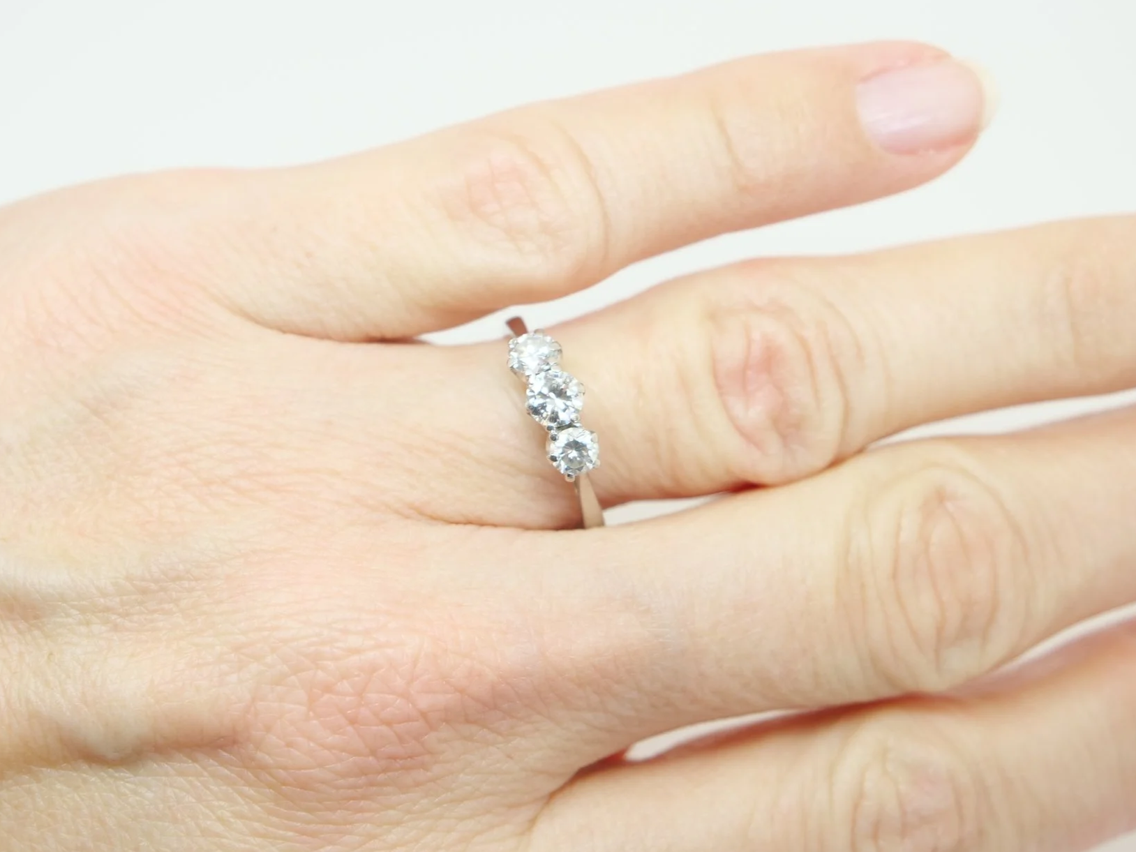 Classic platinum and diamond three stone ring, set with a larger central diamond, with a smaller diamond to each side. Approximately 0.85ct total diamonds.