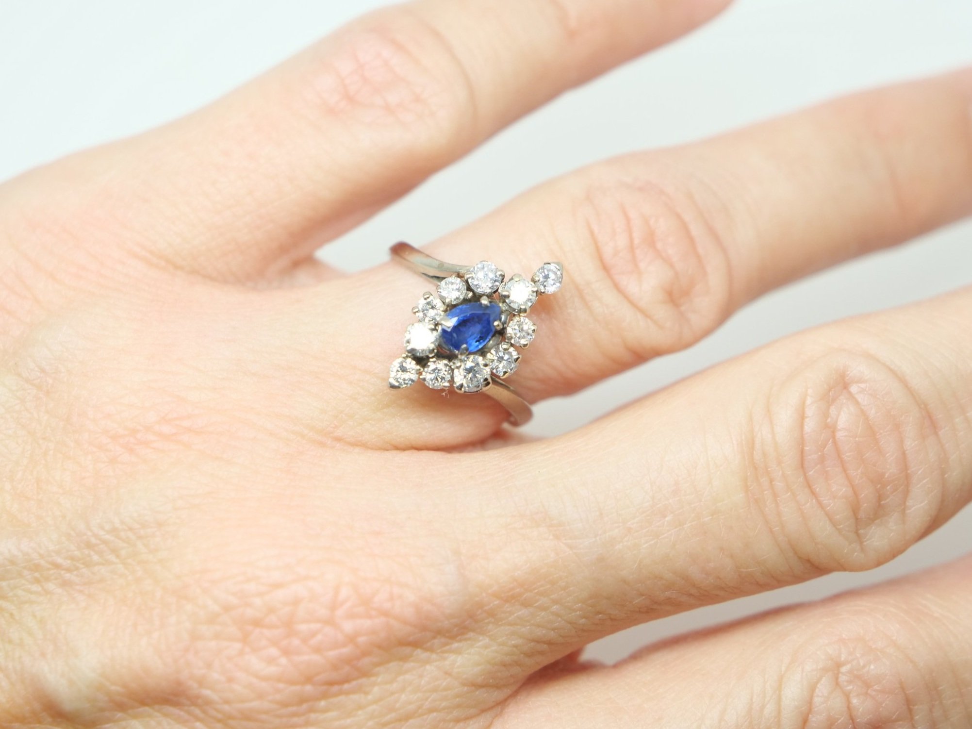 Unusual vintage 18ct gold sapphire and diamond cocktail ring, set with a central pear cut sapphire and surrounded by brilliant cut diamonds of different sizes.